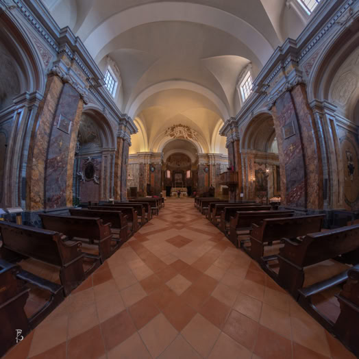 Interno di una chiesa con navata centrale, banchi di legno su entrambi i lati e soffitto a volta.