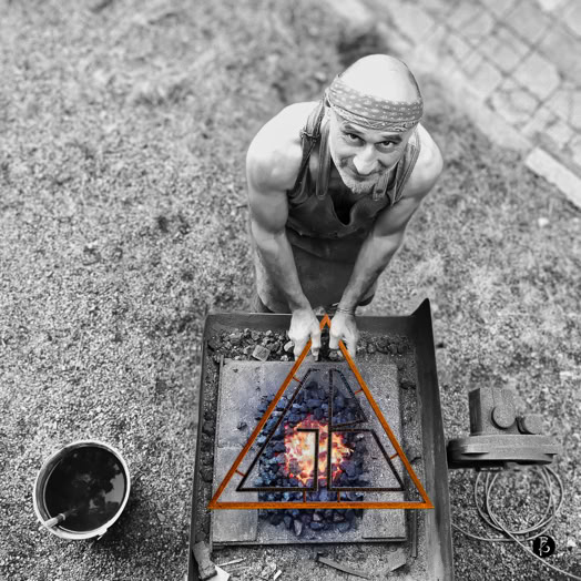 Uomo calvo con bandana, in piedi sopra una fucina con carbone ardente, visto dall'alto.