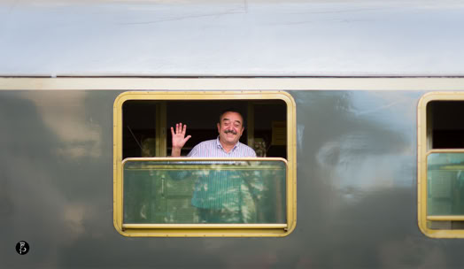 Uomo che saluta dalla finestra di un treno.