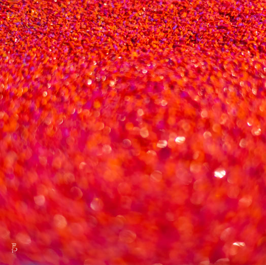 Superficie sfocata di colore rosso con riflessi brillanti.