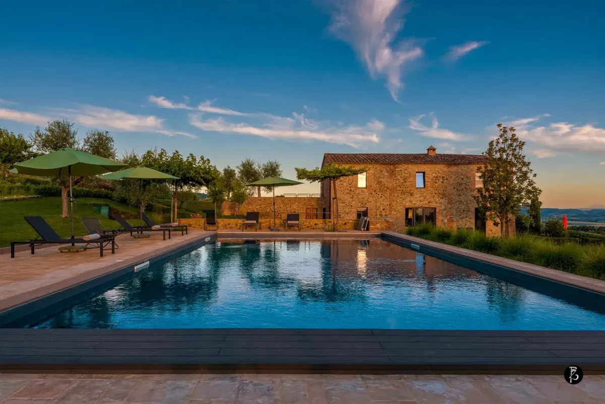 Luce dorata al tramonto — Piscina a sfioro — Casale rurale — Facciata in pietra — fotografia professionale Paolo Zuchegna