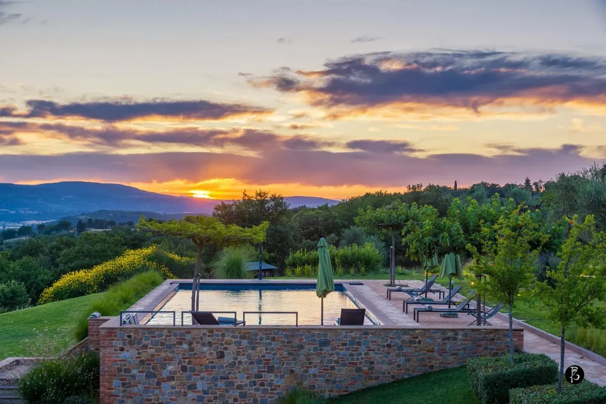 Luce dorata al tramonto — Colline umbre — Piscina a sfioro — Facciata in pietra — fotografia professionale Paolo Zuchegna