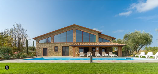 Edificio in pietra con ampie vetrate, piscina in primo piano, sedie a sdraio e prato verde circostante, cielo sereno.