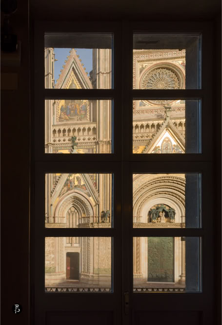 Vista di una cattedrale gotica attraverso una finestra a griglia.