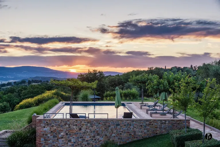 Luce dorata al tramonto — Colline umbre — Piscina a sfioro — Facciata in pietra — Villa di lusso — Toscana — fotografia professionale Paolo Zuchegna